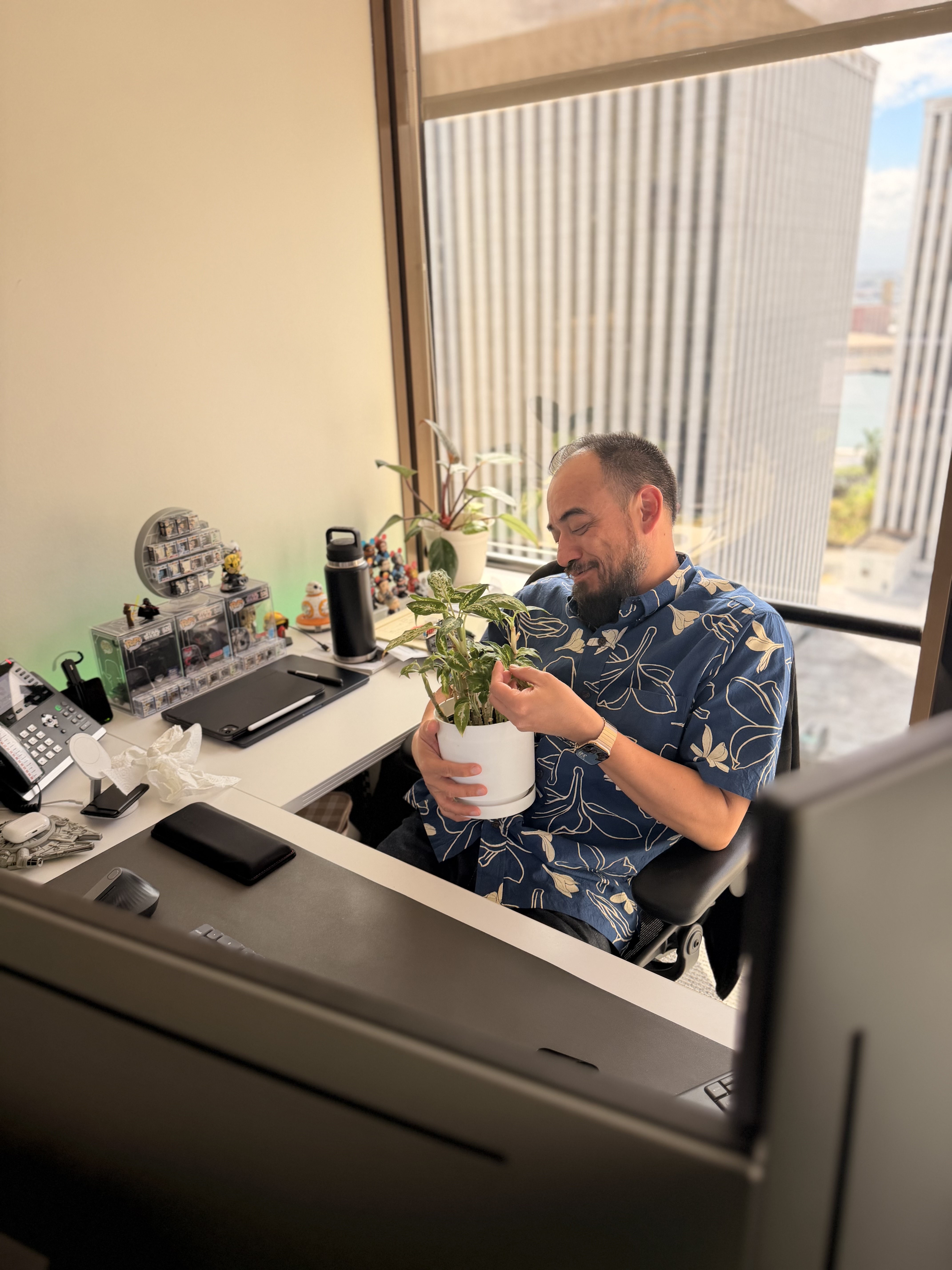 Eric examining a plant he is holding, with a slight smile